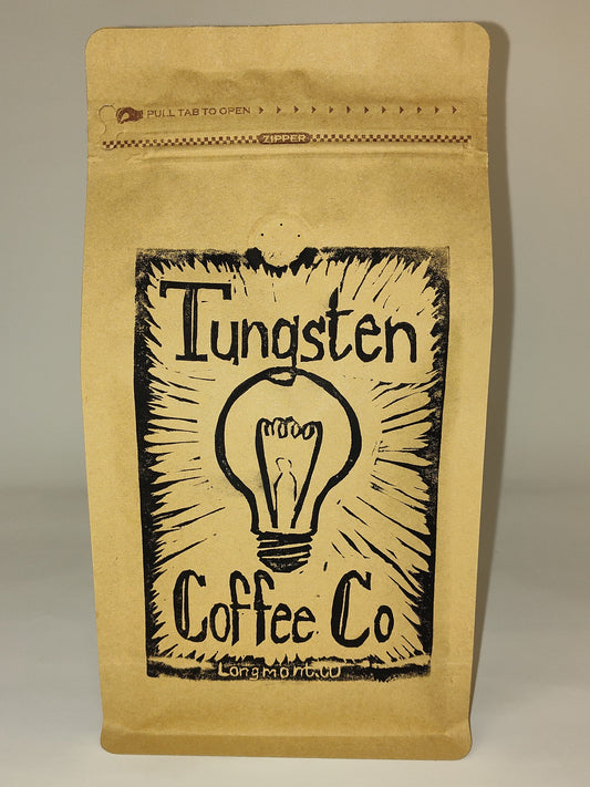 A kraft paper coffee bag with a black printed logo reading 'Tungsten Coffee Co' and a lightbulb illustration, standing upright against a plain light gray background.